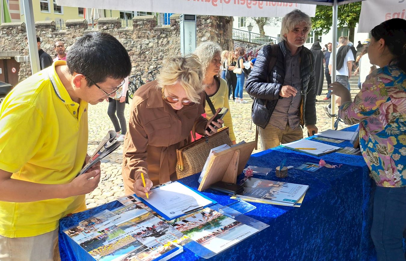 Image for article Німеччина. Китайці виходять із лав компартії біля інформаційного стенда Фалунь Дафа